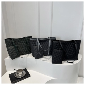Trois couleurs de sacs cabas matelassés exposés sur un support blanc minimaliste
