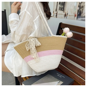 Détail d'un sac cabas tissé tricolore avec un nœud en dentelle et des franges