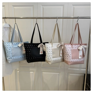 Row of textured tote bags in four pastel colors with decorative scarves on handles