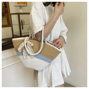 Détail du sac cabas tissé main avec couleurs contrastées, nœud en dentelle et anses corde