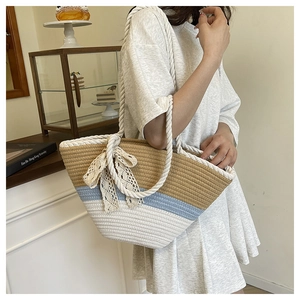 Detail of a color-block woven tote bag with lace bow decoration and sturdy rope handles