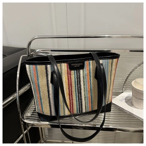 Détail du grand sac cabas en paille tissée multicolore avec anses en cuir noir robuste