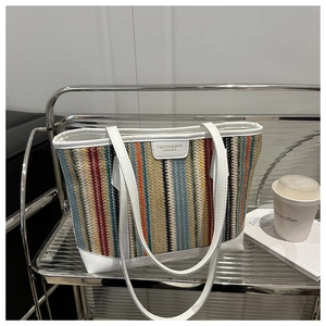 Détail du grand sac cabas en paille tissée colorée avec bordures en cuir blanc