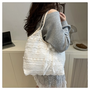 Close-up of intricate white lace embroidery and decorative bow on the summer tote bag