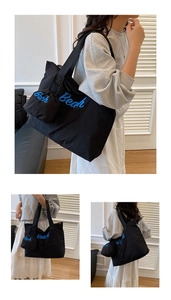Dettaglio della grande borsa tote nera in tela con ricamo Beach e pochette coordinata