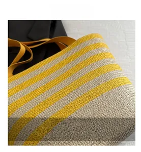 Macro detail of yellow and white striped woven tote with textured bamboo handle