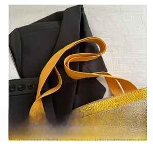 Detail view of woven handbag with bamboo handles and yellow striped textured fabric