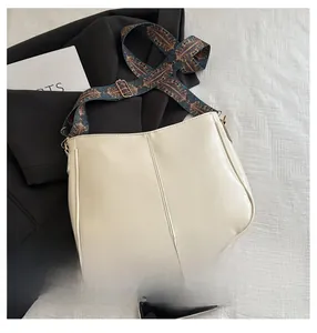 Detail of cream faux leather tote bag featuring a vintage ethnic pattern wide shoulder strap