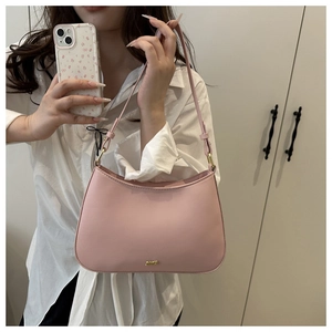 Detail of a pink crescent-shaped shoulder bag with adjustable strap and gold metal logo