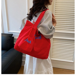Red canvas tote bag set with blue Beach script detail and matching small pouch