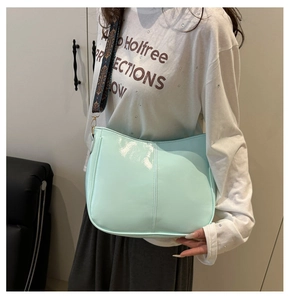 Detail of light green glossy leather crossbody bag with geometric ethnic shoulder strap