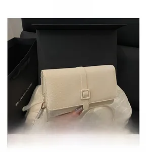 Détail du sac bandoulière crème en texture tissée dans un coffret cadeau noir de luxe