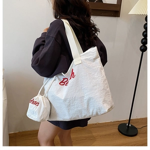Detail of white canvas tote set with red Beach print showing soft drape and inner pouch