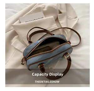 Detail view of the spacious interior of a denim Boston bag showing daily essentials