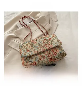 Detail der Blumenstickerei auf Vintage-Jacquard-Tasche mit rotem Kettenriemen