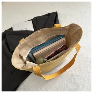 Detail view of large capacity striped straw woven bag with internal zipper pocket