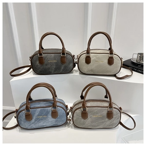 Collection of cylinder Boston bags in denim blue, gray and beige on white display stands