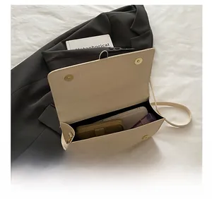 Détail de l'espace intérieur du sac bandoulière beige en cuir texturé à fermoirs aimantés
