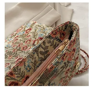 Detailaufnahme der floralen Jacquard-Textur mit Metallreißverschluss und Goldkettengurt