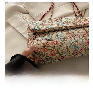 Detaillierte Makroansicht von Retro-Blumen-Jacquard-Stoff und feiner Naht einer Umhängetasche