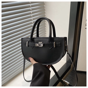 Détail du sac à main noir semi-circulaire avec boucle argentée et lanières en cuir