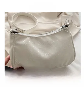 Detail shot of white faux snake leather texture and silver zipper on underarm bag