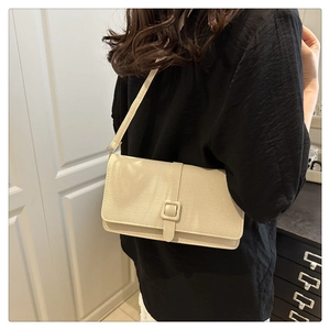 Vue détaillée d'un sac à bandoulière beige rectangulaire avec boucle décorative chic