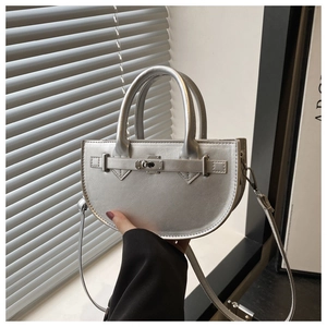 Détail d'un sac demi-lune argenté avec finition métallique et boucle décorative chic