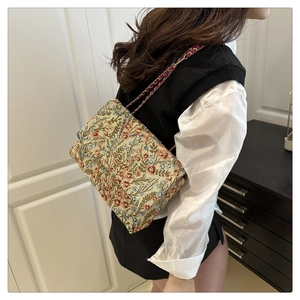 Detail der floral bestickten Umhängetasche mit goldener Kette und Vintage-Muster