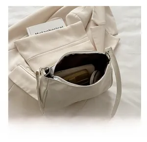 Spacious interior of beige leather baguette bag showing storage for daily essentials