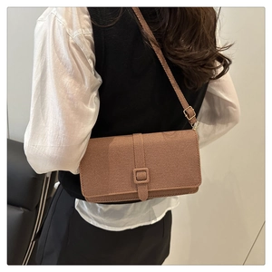 Détail de la texture en sergé marron et de la bandoulière réglable du sac vintage
