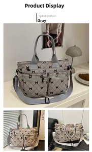 Detail of grey corduroy tote bag with black bow print and dual front zipper pockets