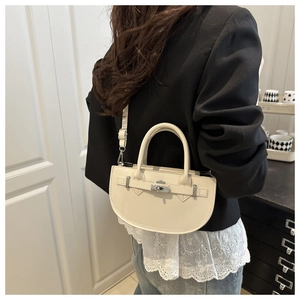 Petit sac à main blanc demi-lune porté à l'épaule avec une bandoulière fine