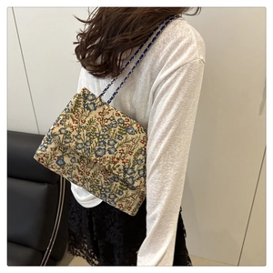 Blumige Brokat-Schultertasche mit Kettenriemen am Modell für Vintage-Look