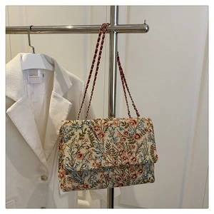 Detailansicht der geblümten Tweed-Umhängetasche mit goldener Kette und feiner Textur