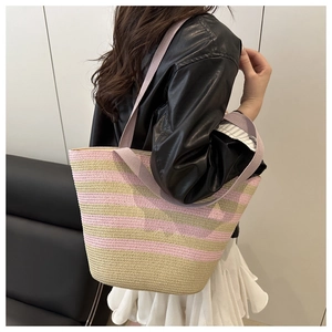Detail of pink striped straw beach tote bag with thick handles for summer vacation