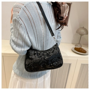 Close-up of stylish black and white snakeskin embossed bag worn on shoulder