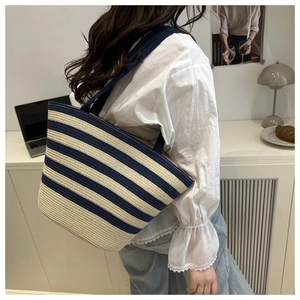 Detail of navy and beige striped straw tote bag showing the textured weave and capacity