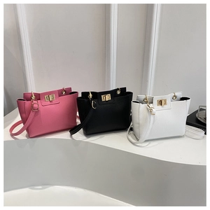 Vue détaillée de trois sacs bandoulière minimalistes en cuir avec fermoirs dorés