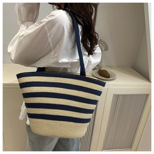 Detailed side view of the striped woven tote bag featuring navy blue and beige colors