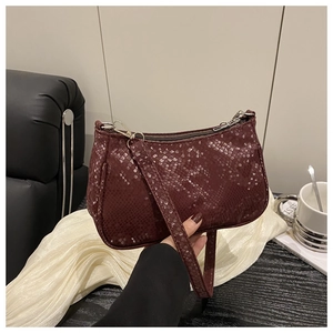 Detail of burgundy snakeskin texture shoulder bag with zipper and silver hardware