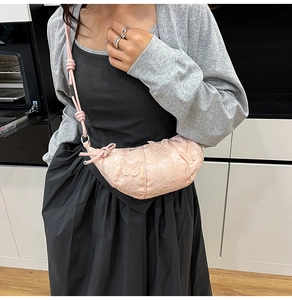 Dettaglio borsa a tracolla rosa con ricami, farfalle 3D e tracolla con nodi decorativi