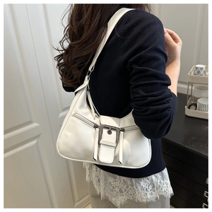 Detailed side view of white crescent leather shoulder bag with vintage metal buckle decoration