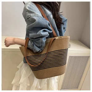 Détail d'un grand sac cabas tissé avec cordes en coton marron et rayures noires à l'épaule
