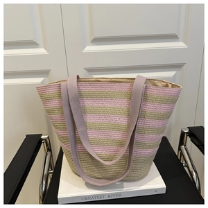 Detail view of large straw tote bag with pink and green stripes and fabric handles
