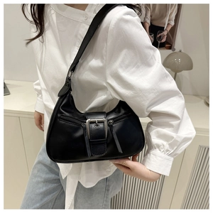 Close-up of a black crescent shoulder bag featuring silver metal buckles and zippers