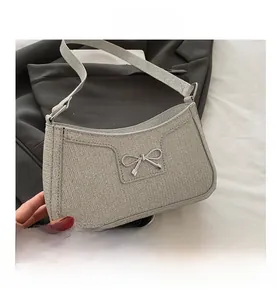 Vue détaillée du sac à bandoulière en sequins argentés avec nœud en métal et texture