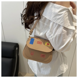 Detail showing the large saddle bag size and cartoon print worn by a fashion model
