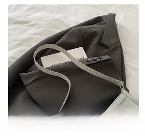 Vue détaillée du sac gris texturé avec nœud métallique élégant et bandoulière fine