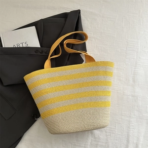 Handwoven straw tote bag with yellow and cream stripes for summer beach vacation